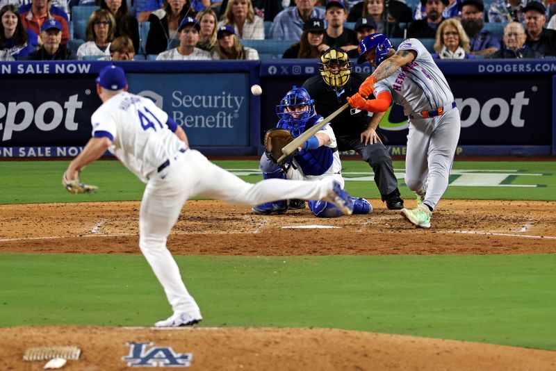 Oct 20, 2024; Los Angeles, California, USA; New York Mets catcher Francisco Alvarez (4) hits an RBI sacrifice fly during the seventh inning against the Los Angeles Dodgers during game six of the NLCS for the 2024 MLB playoffs at Dodger Stadium. Mandatory Credit: Jason Parkhurst-Imagn Images