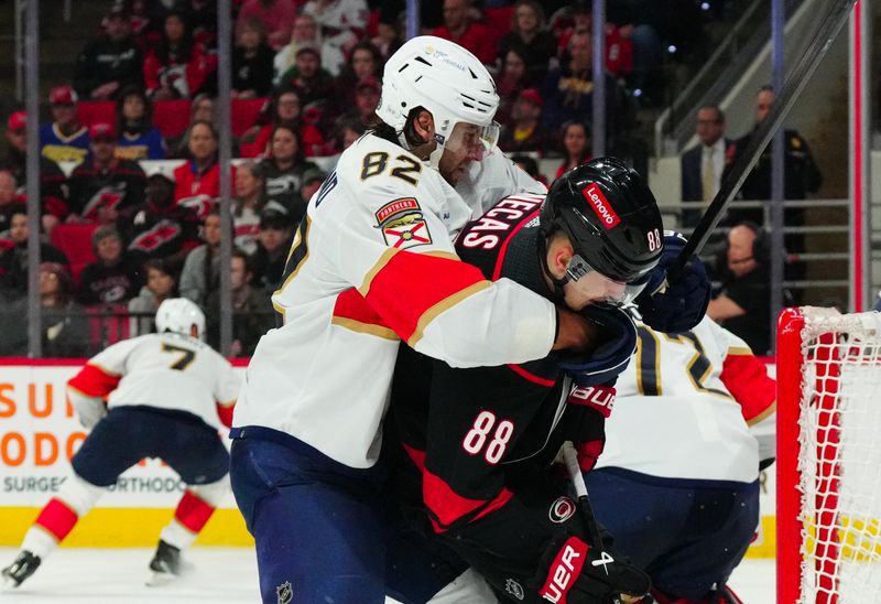 Mar 14, 2024; Raleigh, North Carolina, USA; Florida Panthers center Kevin Stenlund (82) grabs hold of Carolina Hurricanes center Martin Necas (88) during the third period at PNC Arena. Mandatory Credit: James Guillory-USA TODAY Sports