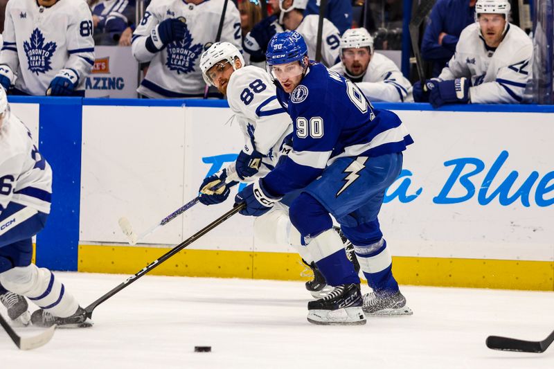 Feb 25, 2026; Tampa, Florida, USA; Tampa Bay Lightning defenseman J.J. Moser (90) and Toronto Maple Leafs forward William Nylander (88) battle for the puck during the first period at Benchmark International Arena. Mandatory Credit: Morgan Tencza-Imagn Images