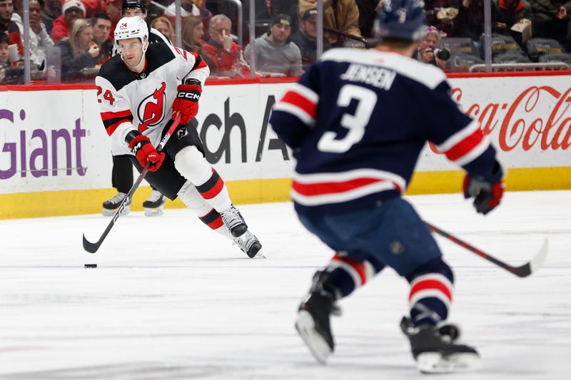 Feb 20, 2024; Washington, District of Columbia, USA; New Jersey Devils defenseman Colin Miller (24) skates with the puck as Washington Capitals defenseman Nick Jensen (3) defends in the first period at Capital One Arena. Mandatory Credit: Geoff Burke-USA TODAY Sports