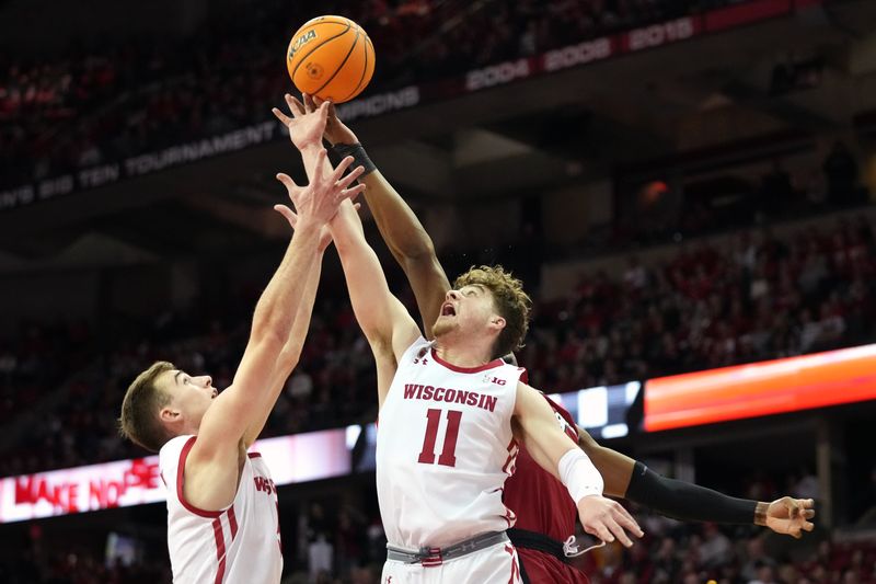 Feb 18, 2023; Madison, Wisconsin, USA;  Wisconsin Badgers forward Tyler Wahl (left) and guard Max Klesmit (11) reach for a rebound against Rutgers Scarlet Knights forward Aundre Hyatt (5) during the first half at the Kohl Center. Mandatory Credit: Kayla Wolf-USA TODAY Sports