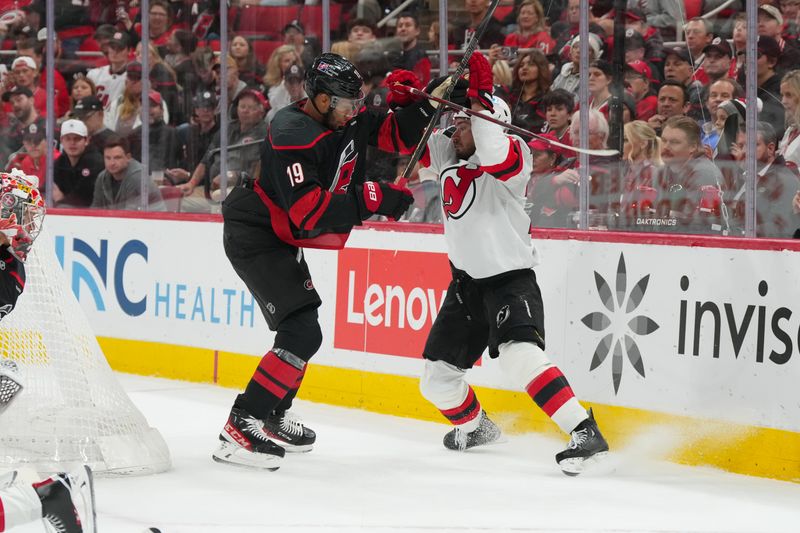 Oct 9, 2025; Raleigh, North Carolina, USA;  Carolina Hurricanes defenseman K'Andre Miller (19) checks New Jersey Devils right wing Timo Meier (28) during the second period at Lenovo Center. Mandatory Credit: James Guillory-Imagn Images
