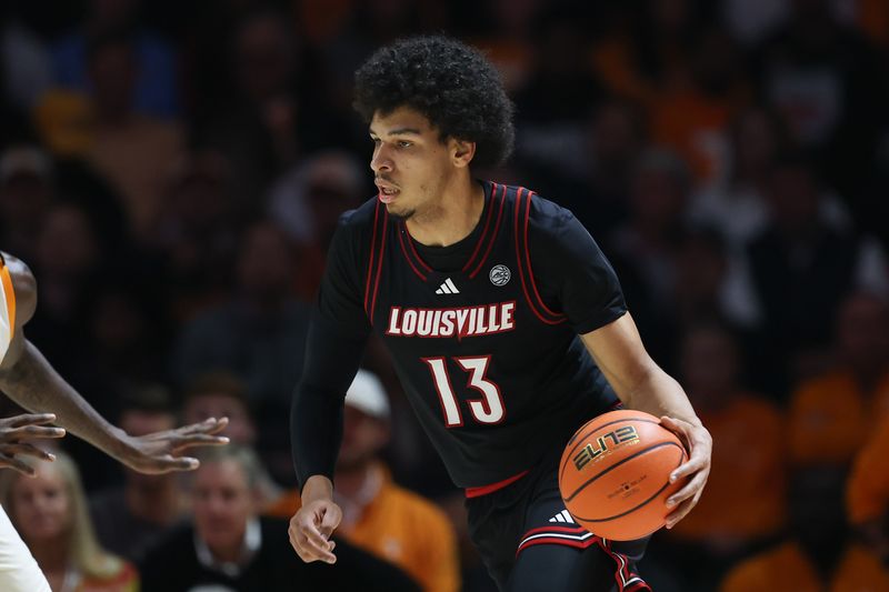 Dec 16, 2025; Knoxville, Tennessee, USA;  Louisville Cardinals forward Sananda Fru (13) moves the ball against the Tennessee Volunteers during the first half at Thompson-Boling Arena at Food City Center. Mandatory Credit: Randy Sartin-Imagn Images