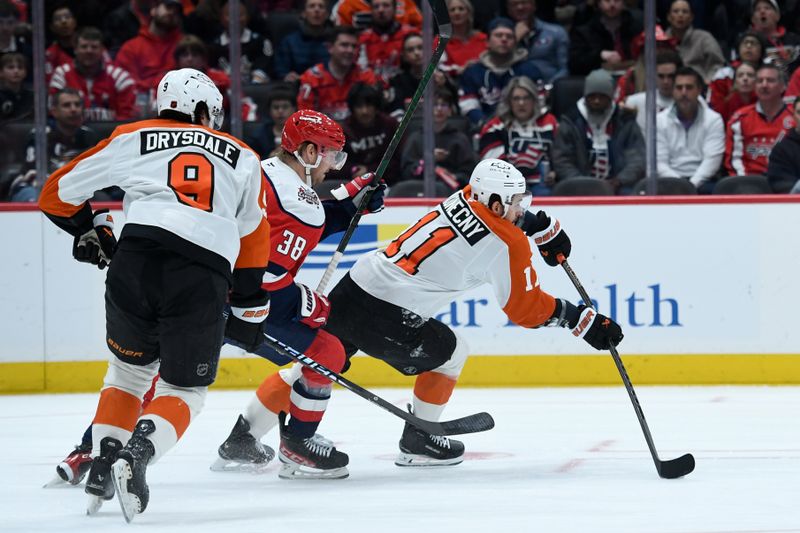 Feb 25, 2026; Washington, District of Columbia, USA; Philadelphia Flyers right wing Travis Konecny (11) passes the puck against Washington Capitals defenseman Rasmus Sandin (38) during the first period at Capital One Arena. Mandatory Credit: Hannah Foslien-Imagn Images