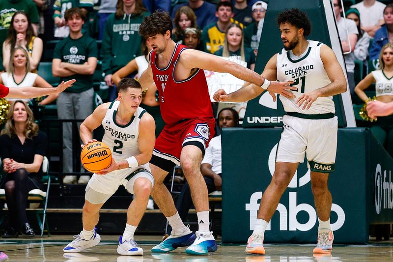 Feb 24, 2026; Fort Collins, Colorado, USA; Colorado State Rams guard Brandon Rechsteiner (2) controls the ball against Fresno State Bulldogs center Wilson Jacques (16) as guard Rashaan Mbemba (21) defends in the first half at Moby Arena. Mandatory Credit: Isaiah J. Downing-Imagn Images