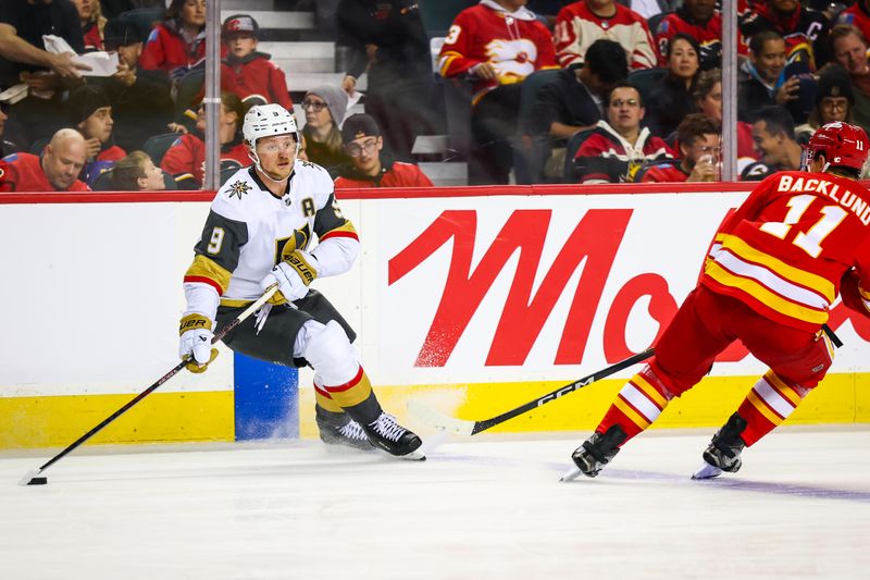 Oct 14, 2025; Calgary, Alberta, CAN; Vegas Golden Knights center Jack Eichel (9) controls the puck against Calgary Flames center Mikael Backlund (11) during the second period at Scotiabank Saddledome. Mandatory Credit: Sergei Belski-Imagn Images