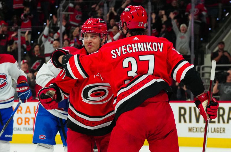 Dec 28, 2023; Raleigh, North Carolina, USA; Carolina Hurricanes right wing Jesper Fast (71) is congratulated by  right wing Andrei Svechnikov (37) after his goal against the Montreal Canadiens during the first period at PNC Arena. Mandatory Credit: James Guillory-USA TODAY Sports