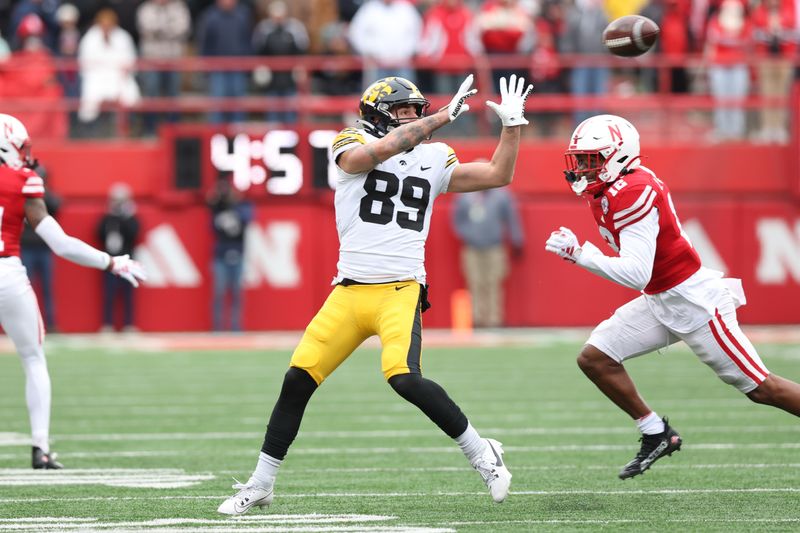 Nov 24, 2023; Lincoln, Nebraska, USA; Iowa Hawkeyes wide receiver Nico Ragaini (89) catches a pass in front of Nebraska Cornhuskers defensive back Omar Brown (12) at Memorial Stadium. Mandatory Credit: Reese Strickland-USA TODAY Sports