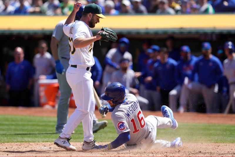 Apr 19, 2023; Oakland, California, USA; Chicago Cubs right fielder Patrick Wisdom (16) scores a run past Oakland Athletics relief pitcher Sam Moll (60) during the sixth inning at Oakland-Alameda County Coliseum. Mandatory Credit: Darren Yamashita-USA TODAY Sports