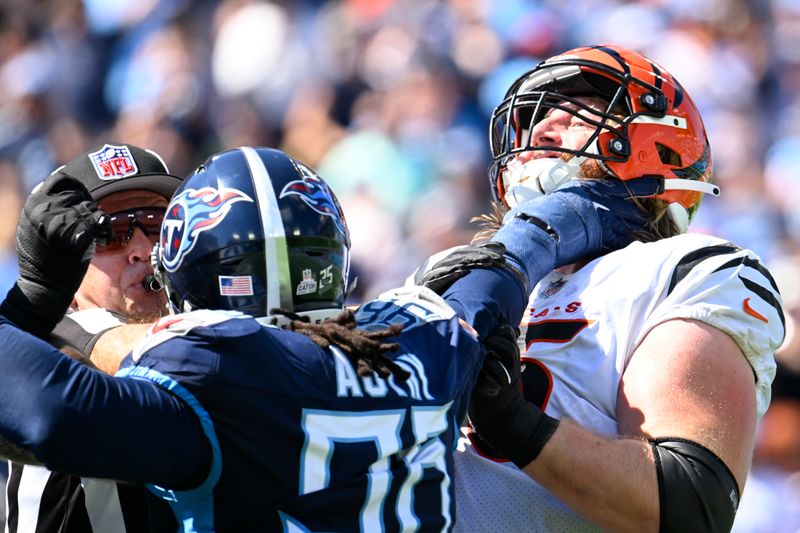 Tennessee Titans defensive end Denico Autry (96) and Cincinnati Bengals guard Alex Cappa (65) go at it as a referee tries to separate them during an NFL football game Sunday, Sept. 30, 2023 in Nashville, Tenn. (AP Photo/John Amis)