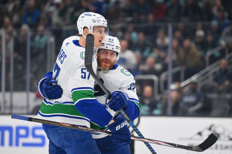 Feb 22, 2024; Seattle, Washington, USA; Vancouver Canucks defenseman Tyler Myers (57) and defenseman Ian Cole (82) celebrate after a goal scored against the Seattle Kraken by right wing Conor Garland (8) (not pictured) during the first period at Climate Pledge Arena. Mandatory Credit: Steven Bisig-USA TODAY Sports