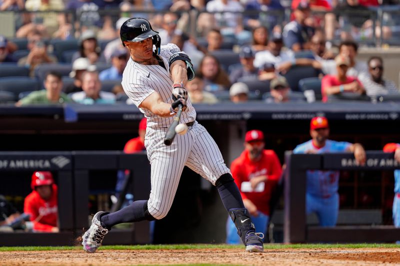 Aug 31, 2024; Bronx, New York, USA; New York Yankees designated hitter Giancarlo Stanton (27) hits an RBI double against the St. Louis Cardinals during the eighth inning at Yankee Stadium. Mandatory Credit: Gregory Fisher-USA TODAY Sports