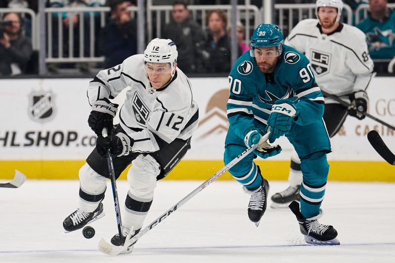 Apr 4, 2024; San Jose, California, USA; Los Angeles Kings left wing Trevor Moore (12) plays the puck against San Jose Sharks right wing Justin Bailey (90) during the first period at SAP Center at San Jose. Mandatory Credit: Robert Edwards-USA TODAY Sports