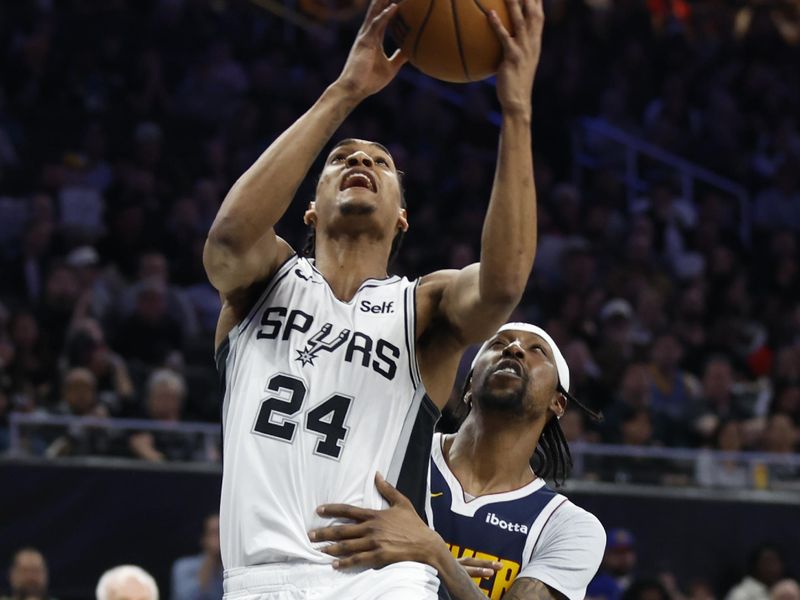 AUSTIN, TX - MARCH 15: Devin Vassell #24 of the San Antonio Spurs is fouled by Kentavious Caldwell-Pope #5 of the Denver Nuggets in the first half at Moody Center on March 15, 2024 in Austin, Texas. NOTE TO USER: User expressly acknowledges and agrees that, by downloading and or using this photograph, User is consenting to terms and conditions of the Getty Images License Agreement. (Photo by Ronald Cortes/Getty Images)