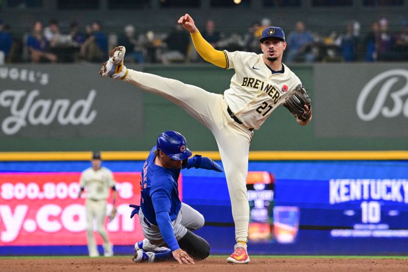 May 27, 2024; Milwaukee, Wisconsin, USA; Milwaukee Brewers shortstop Willy Adames (27) jumps out of the way after forcing out Chicago Cubs second baseman Nico Hoerner (2) in the fourth inning at American Family Field. Mandatory Credit: Benny Sieu-USA TODAY Sports