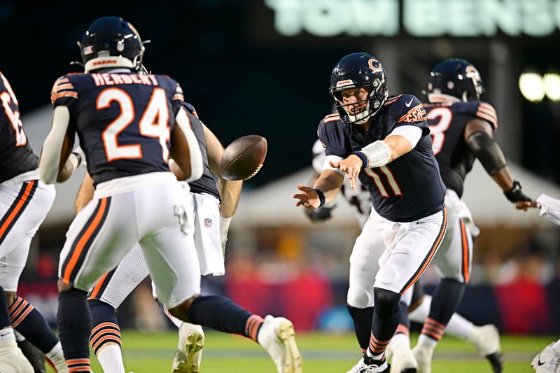 Chicago Bears quarterback Brett Rypien (11) tosses the ball to running back Khalil Herbert (24) during the first half of an NFL exhibition Hall of Fame football game against the Houston Texans, Thursday, Aug. 1, 2024, in Canton, Ohio. (AP Photo/David Dermer)