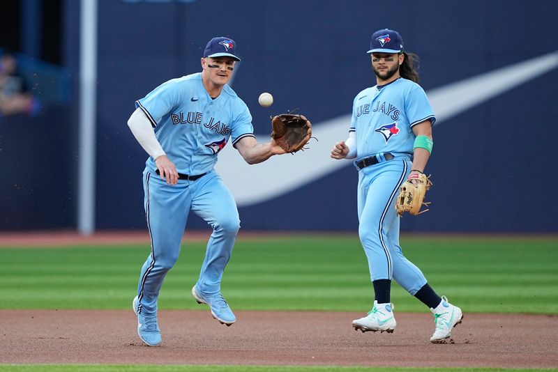 May 30, 2023; Toronto, Ontario, CAN; Toronto Blue Jays third baseman Matt Chapman (26) catches a ground ball hit by Milwaukee Brewers designated hitter Darin Ruf (not pictured) as Toronto Blue Jays shortstop Bo Bichette (11) looks on during the first inning at Rogers Centre. Mandatory Credit: John E. Sokolowski-USA TODAY Sports