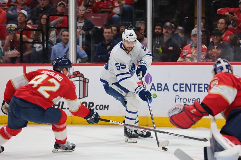 Dec 2, 2025; Sunrise, Florida, USA; Toronto Maple Leafs center Nicolas Roy (55) moves the puck against Florida Panthers defenseman Gustav Forsling (42) during the second period at Amerant Bank Arena. Mandatory Credit: Sam Navarro-Imagn Images