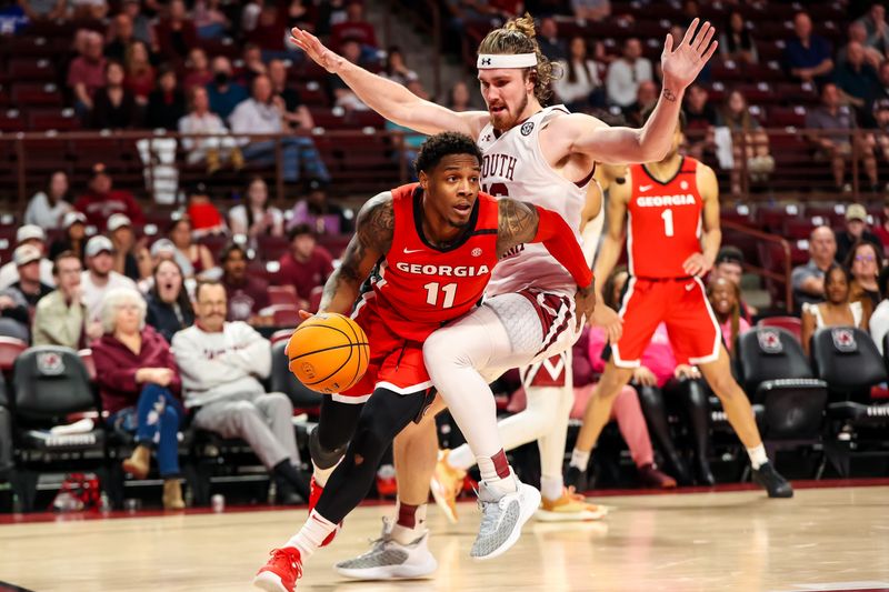 Mar 4, 2023; Columbia, South Carolina, USA; Georgia Bulldogs guard Justin Hill (11) drives around South Carolina Gamecocks forward Hayden Brown (10) in the second half at Colonial Life Arena. Mandatory Credit: Jeff Blake-USA TODAY Sports