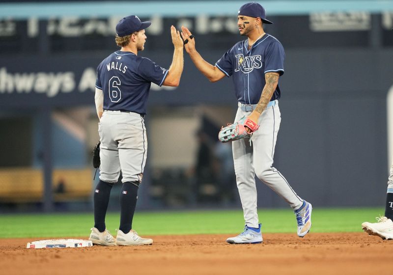 Jul 23, 2024; Toronto, Ontario, CAN; Tampa Bay Rays shortstop Taylor Walls (6) and center fielder Jose Siri (22) celebrate the win against the Toronto Blue Jays at the end of the ninth inning at Rogers Centre. Mandatory Credit: Nick Turchiaro-USA TODAY Sports