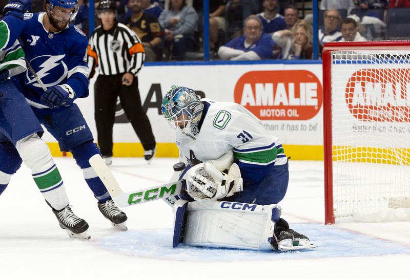 Oct 15, 2024; Tampa, Florida, USA;Vancouver Canucks goaltender Arturs Silovs (31) makes a save against the Tampa Bay Lightning during the first period at Amalie Arena. Mandatory Credit: Kim Klement Neitzel-Imagn Images