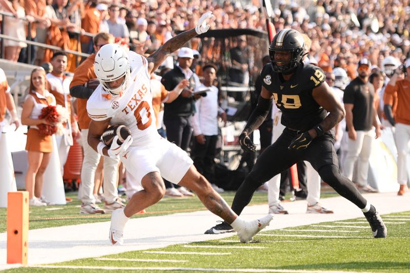 Oct 26, 2024; Nashville, Tennessee, USA;  Vanderbilt Commodores safety Jalen Gilbert (18) drags Texas Longhorns wide receiver DeAndre Moore Jr. (0) down just before the goal line during the first half at FirstBank Stadium. Mandatory Credit: Steve Roberts-Imagn Images