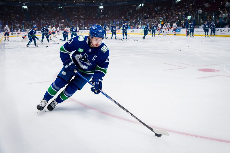 Nov 15, 2023; Vancouver, British Columbia, CAN; Vancouver Canucks defenseman Quinn Hughes (43) handles the puck during warm up prior to a game against the New York Islanders at Rogers Arena. Mandatory Credit: Bob Frid-USA TODAY Sports