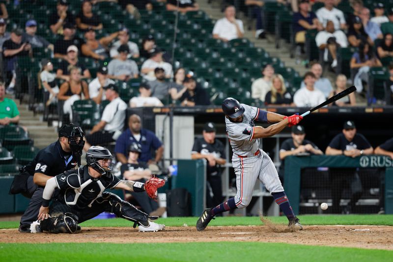 Jul 8, 2024; Chicago, Illinois, USA; Minnesota Twins outfielder Manuel Margot (13) hits an RBI-ground out against the Chicago White Sox during the 11th inning at Guaranteed Rate Field. Mandatory Credit: Kamil Krzaczynski-USA TODAY Sports