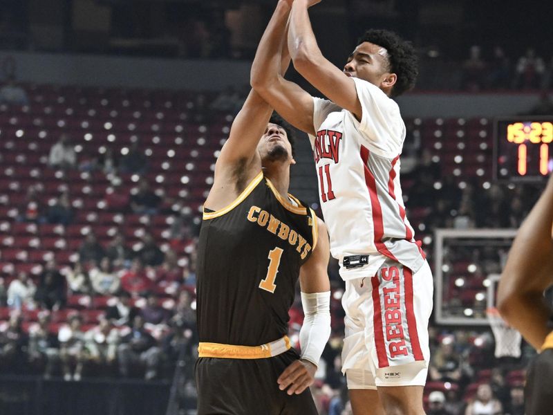 Feb 3, 2024; Las Vegas, Nevada, USA; UNLV Rebels guard Dedan Thomas Jr. (11) is fouled by Wyoming Cowboys guard Brendan Wenzel (1) in the first half at Thomas & Mack Center. Mandatory Credit: Candice Ward-USA TODAY Sports