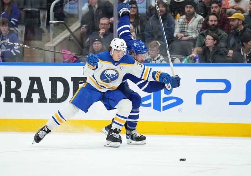 Mar 6, 2024; Toronto, Ontario, CAN; Buffalo Sabres defenseman Ryan Johnson (33) battles for the puck withToronto Maple Leafs defenseman Simon Benoit (2) during the third period at Scotiabank Arena. Mandatory Credit: Nick Turchiaro-USA TODAY Sports