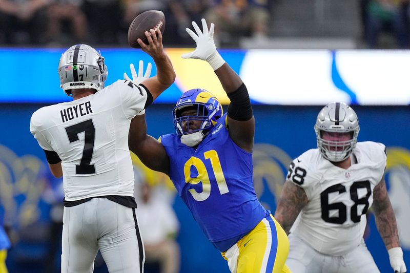 Los Angeles Rams defensive tackle Kobie Turner pressures Las Vegas Raiders quarterback Brian Hoyer (7) during the first half of a preseason NFL football game Saturday, Aug. 19, 2023, in Inglewood, Calif. (AP Photo/Mark J. Terrill)