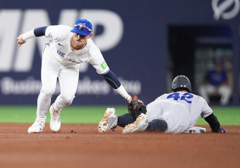 Apr 15, 2024; Toronto, Ontario, CAN; New York Yankees outfielder Trent Grisham is tagged out at second base trying to steal by Toronto Blue Jays second baseman Cavan Biggio (8) all wearing number 42 for Jackie Robinson Day during the fifth inning at Rogers Centre. Mandatory Credit: Nick Turchiaro-USA TODAY Sports