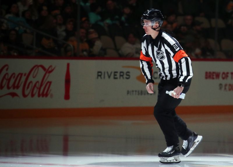 Jan 14, 2025; Pittsburgh, Pennsylvania, USA;  NHL referee TJ Luxmore (21) takes the ice to officiate the game between the Seattle Kraken and the Pittsburgh Penguins  at PPG Paints Arena. Mandatory Credit: Charles LeClaire-Imagn Images