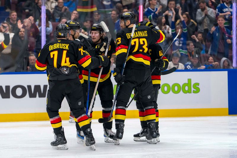 Dec 6, 2024; Vancouver, British Columbia, CAN; Vancouver Canucks forward Jake DeBrusk (74) and forward Elias Pettersson (40) and forward Brock Boeser (6) and defenseman Quinn Hughes (43) and defenseman Vincent Desharnais (73) celebrate against the Columbus Blue Jackets during the second period at Rogers Arena. Mandatory Credit: Bob Frid-Imagn Images
