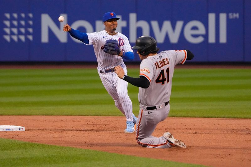 Jul 2, 2023; New York City, New York, USA;  New York Mets shortstop Francisco Lindor (12) attempts to turn a double play after getting the force out on San Francisco Giants first baseman Wilmer Flores (41) sliding into second base during the third inning at Citi Field. Mandatory Credit: Gregory Fisher-USA TODAY Sports