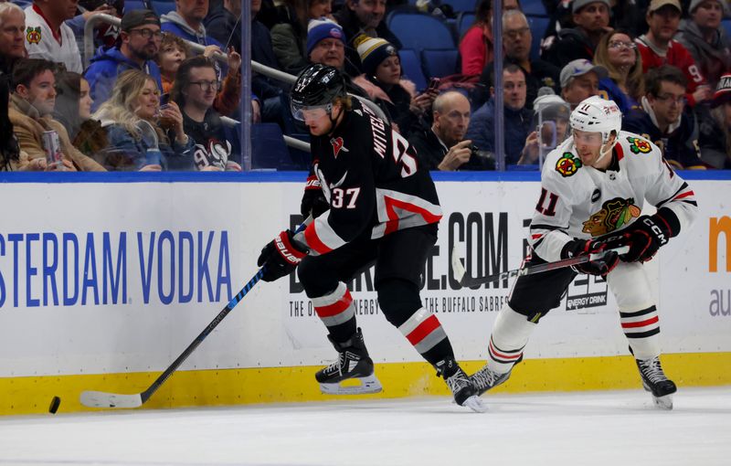 Jan 18, 2024; Buffalo, New York, USA;  Buffalo Sabres center Casey Mittelstadt (37) looks to play the puck as Chicago Blackhawks right wing Taylor Raddysh (11) defends during the first period at KeyBank Center. Mandatory Credit: Timothy T. Ludwig-USA TODAY Sports