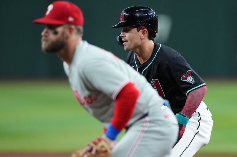 Sep 20, 2025; Phoenix, Arizona, USA; Arizona Diamondbacks outfielder Corbin Carroll (7) leads off first base as Philadelphia Phillies first base Bryce Harper (3) covers the bag during the first inning at Chase Field. Mandatory Credit: Joe Camporeale-Imagn Images