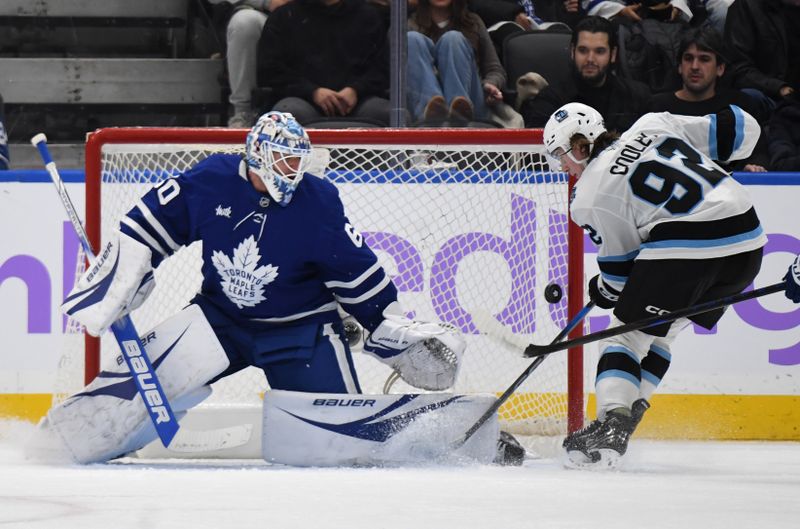 Nov 24, 2024; Toronto, Ontario, CAN;  Utah Hockey Club forward Logan Cooley (92) scores a goal past Toronto Maple Leafs goalie Joseph Woll (60) in the first period at Scotiabank Arena. Mandatory Credit: Dan Hamilton-Imagn Images