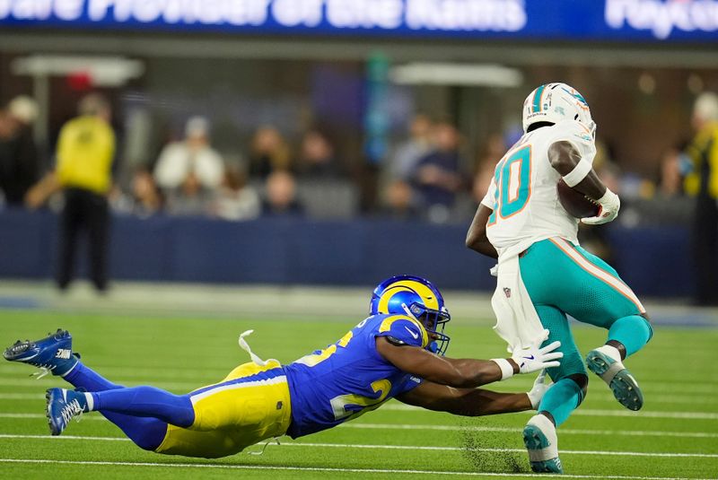 Miami Dolphins wide receiver Tyreek Hill, right, escapes a tackle by Los Angeles Rams safety Kamren Kinchens during the first half of an NFL football game, Monday, Nov. 11, 2024, in Inglewood, Calif. (AP Photo/Marcio Jose Sanchez)