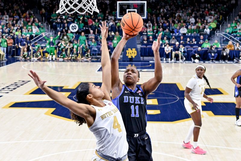 Feb 5, 2023; South Bend, Indiana, USA; Duke Blue Devils guard Jordyn Oliver (11) goes up for a shot as Notre Dame Fighting Irish guard Cassandre Prosper (4) defends in the first half at the Purcell Pavilion. Mandatory Credit: Matt Cashore-USA TODAY Sports