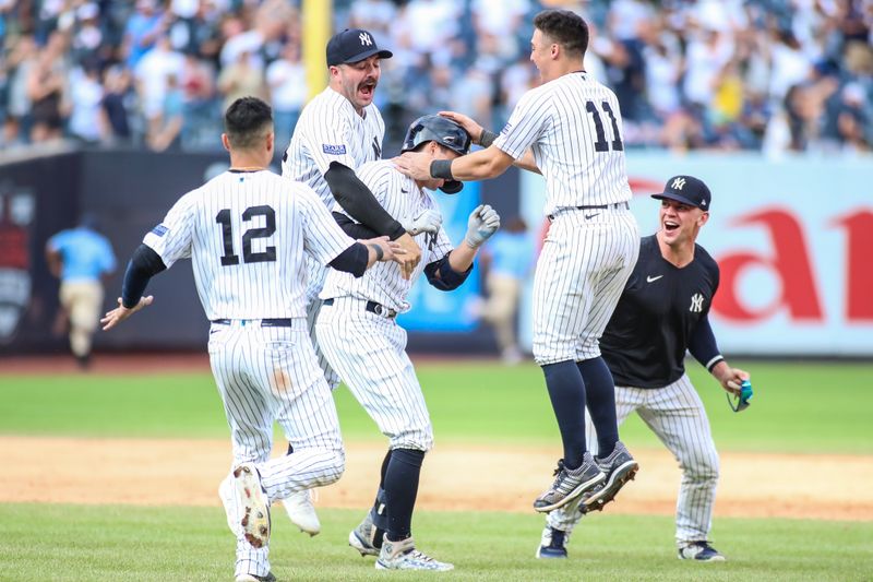 Sep 10, 2023; Bronx, New York, USA;  New York Yankees catcher Kyle Higashioka (66) is mobbed by teammates after hitting a game winning RBI double in the thirteenth inning against the Milwaukee Brewers at Yankee Stadium. Mandatory Credit: Wendell Cruz-USA TODAY Sports