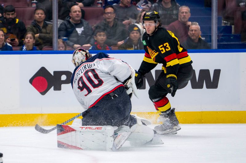 Dec 6, 2024; Vancouver, British Columbia, CAN; Vancouver Canucks forward Teddy Blueger (53) blocks a clearing attempt made by Columbus Blue Jackets goalie Elvis Merzlikins (90) during the second period at Rogers Arena. Mandatory Credit: Bob Frid-Imagn Images