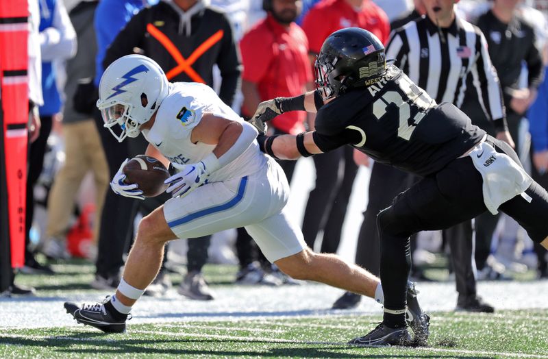 Nov 2, 2024; West Point, New York, USA; Air Force Falcons wide receiver Cade Harris (21) falls down after making a catch in front of Army Black Knights defensive back Casey Larkin (20) during the first half at Michie Stadium. Mandatory Credit: Danny Wild-Imagn Images