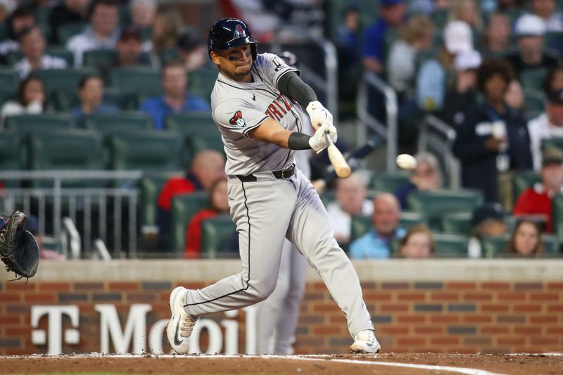 Apr 6, 2024; Atlanta, Georgia, USA; Arizona Diamondbacks catcher Gabriel Moreno (14) hits a single against the Atlanta Braves in the third inning at Truist Park. Mandatory Credit: Brett Davis-USA TODAY Sports