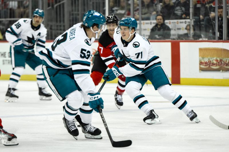 Nov 10, 2024; Newark, New Jersey, USA; San Jose Sharks center Macklin Celebrini (71) moves the puck past New Jersey Devils defenseman Dougie Hamilton (7) during the first period at Prudential Center. Mandatory Credit: John Jones-Imagn Images