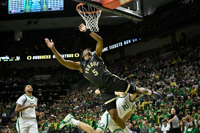 Jan 18, 2025; Eugene, Oregon, USA; Purdue Boilermakers guard Myles Colvin (5) drives to the basket and is fouled by Oregon Ducks center Nate Bittle (32) during the second half at Matthew Knight Arena. Mandatory Credit: Craig Strobeck-Imagn Images