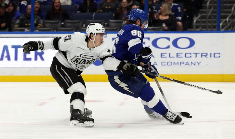 Jan 30, 2025; Tampa, Florida, USA; Los Angeles Kings defenseman Jordan Spence (21) defends Tampa Bay Lightning right wing Nikita Kucherov (86) during the third period at Amalie Arena. Mandatory Credit: Kim Klement Neitzel-Imagn Images