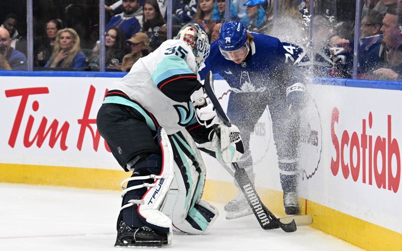 Oct 31, 2024; Toronto, Ontario, CAN;  Seattle Kraken goalie Joey Daccord (35) clears the puck away from Toronto Maple Leafs forward Bobby McMann (74) in the first period at Scotiabank Arena. Mandatory Credit: Dan Hamilton-Imagn Images