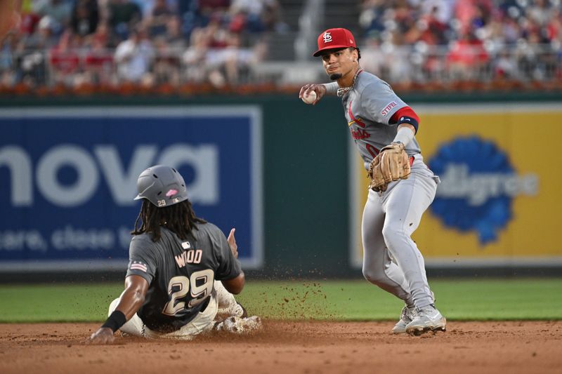 Jul 5, 2024; Washington, District of Columbia, USA; St. Louis Cardinals shortstop Masyn Winn (0) looks to throw to first base in front of Washington Nationals center fielder James Wood (29) during the fifth inning at Nationals Park. Mandatory Credit: Rafael Suanes-USA TODAY Sports