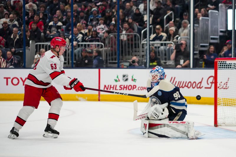 Nov 23, 2024; Columbus, Ohio, USA;  Carolina Hurricanes right wing Jackson Blake (53) deflects the puck against Columbus Blue Jackets goaltender Elvis Merzlikins (90) in the first period at Nationwide Arena. Mandatory Credit: Aaron Doster-Imagn Images